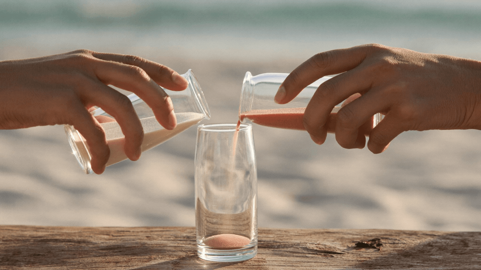Illustrative unity ritual with two colors of prepared sand poured into one keepsake vessel