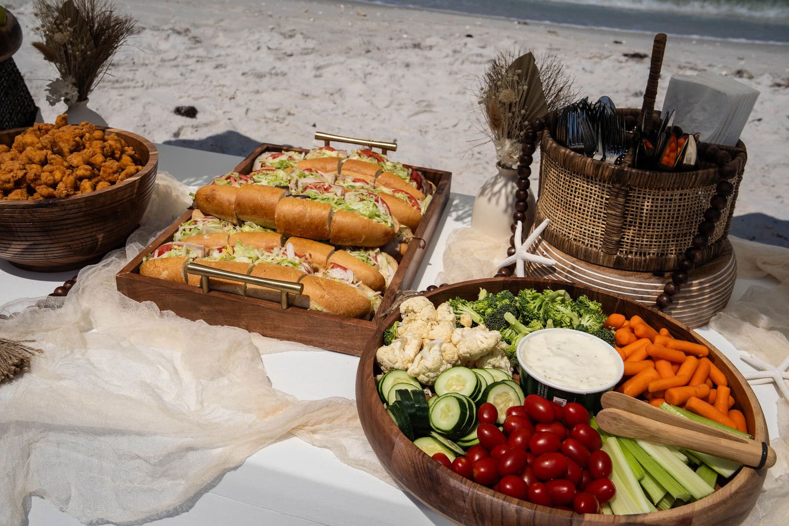 Bridal party in flowing dresses and linen suits on a Florida beach at golden hour