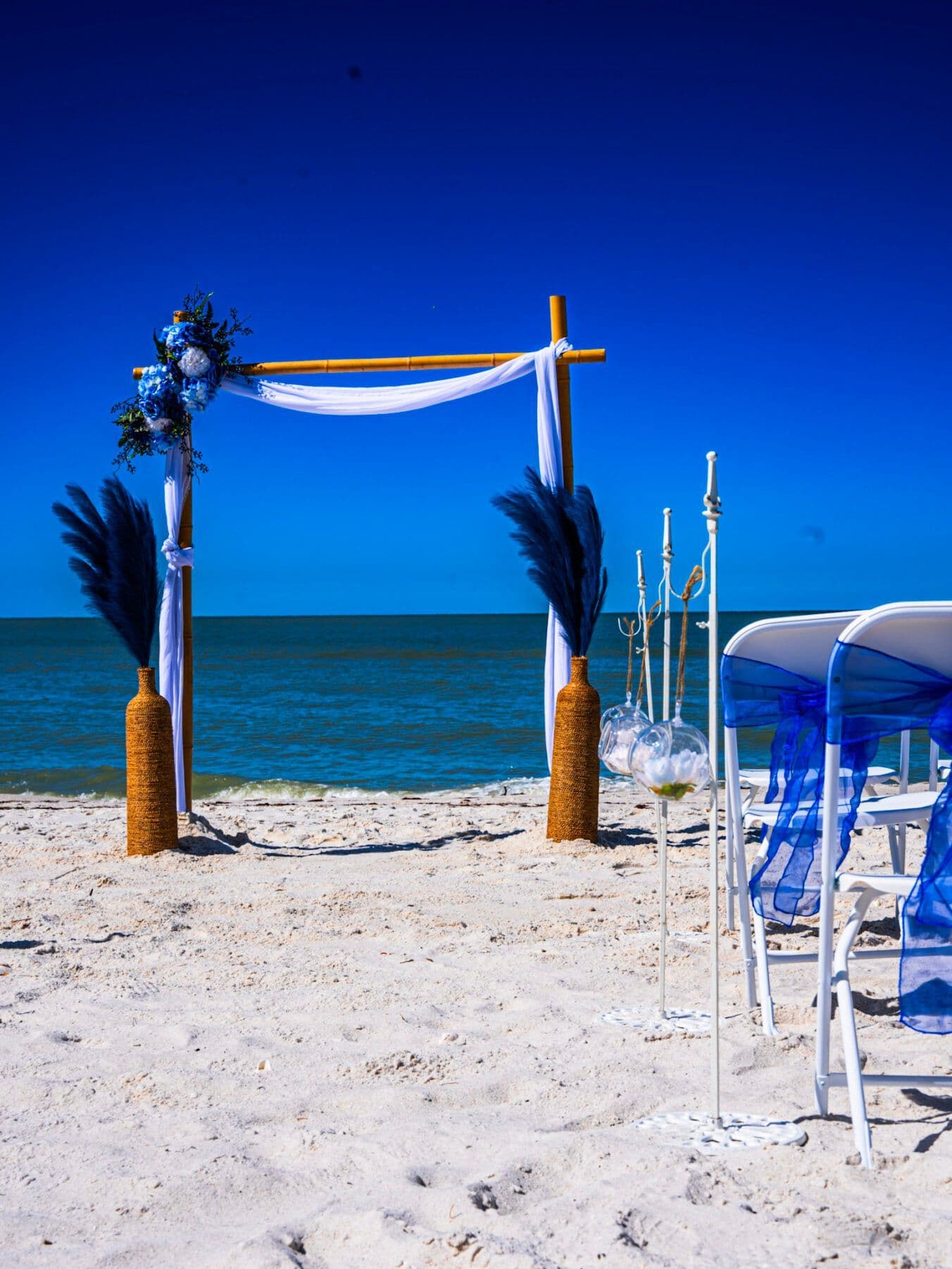 Beach wedding ceremony setup with blue and white decor.