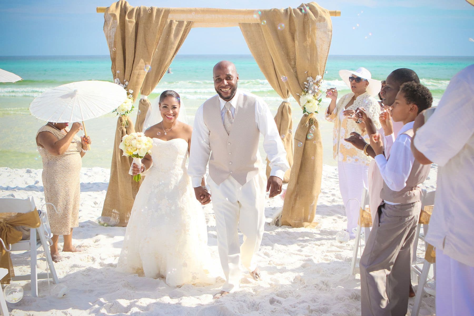 A bride and groom walking down the aisle at their beach wedding